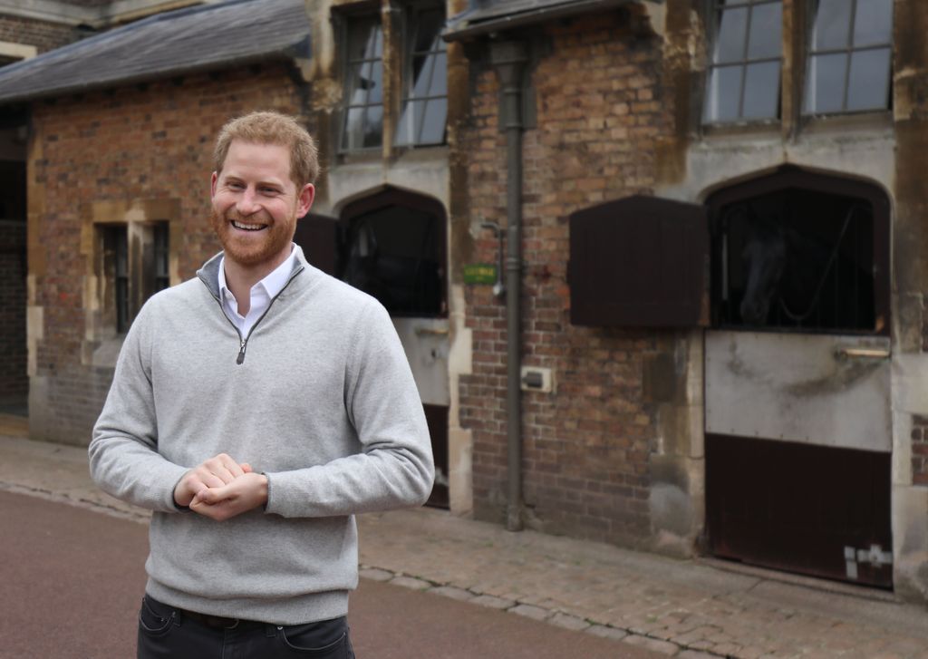 Smiling Prince Harry standing outside stables in Windsor after son's birth
