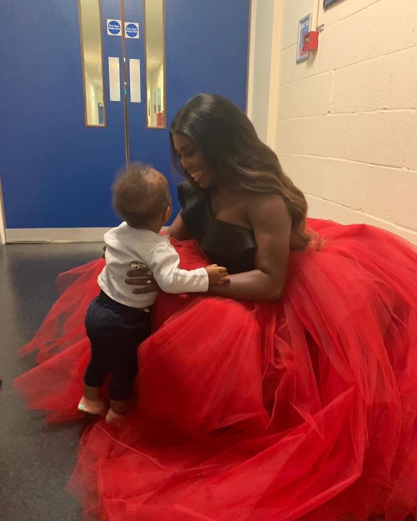 Motsi Mabuse in red dress with daughter 