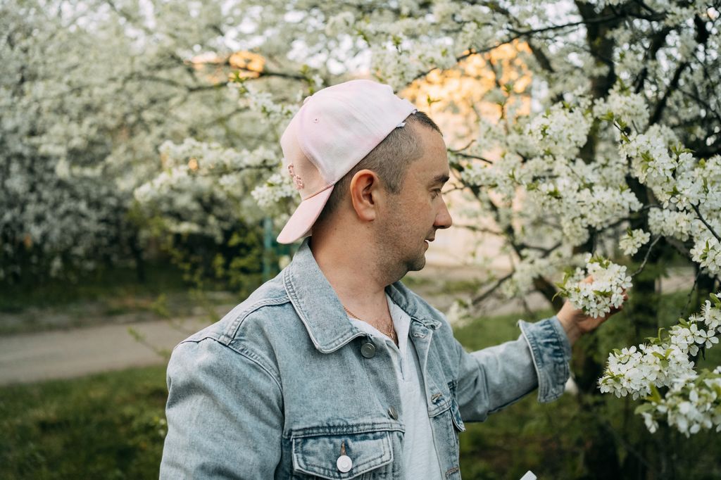 Man admiring and smelling cherry tree flowers in springtime