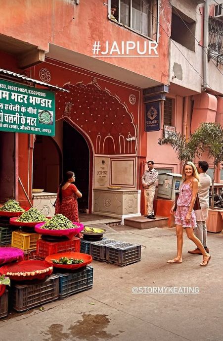 Storm Keating in pink outfit outside Indian market