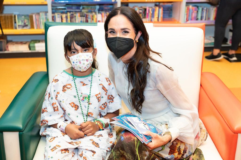 Meghan Markle posing for photograph with young patient