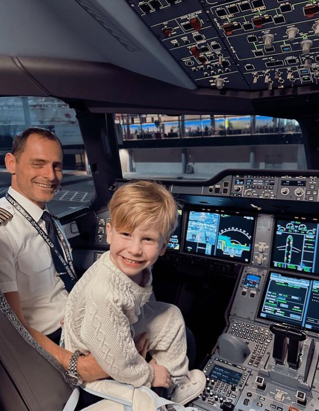 A young boy and a pilot in the cockpoit of an aeroplane