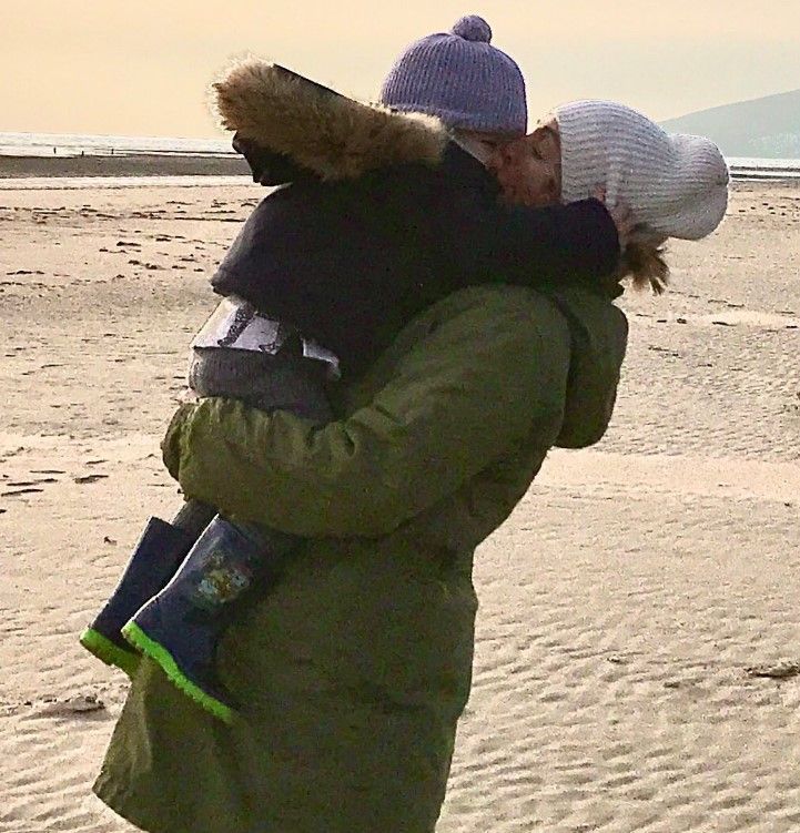 Cat hugs her son on the beach