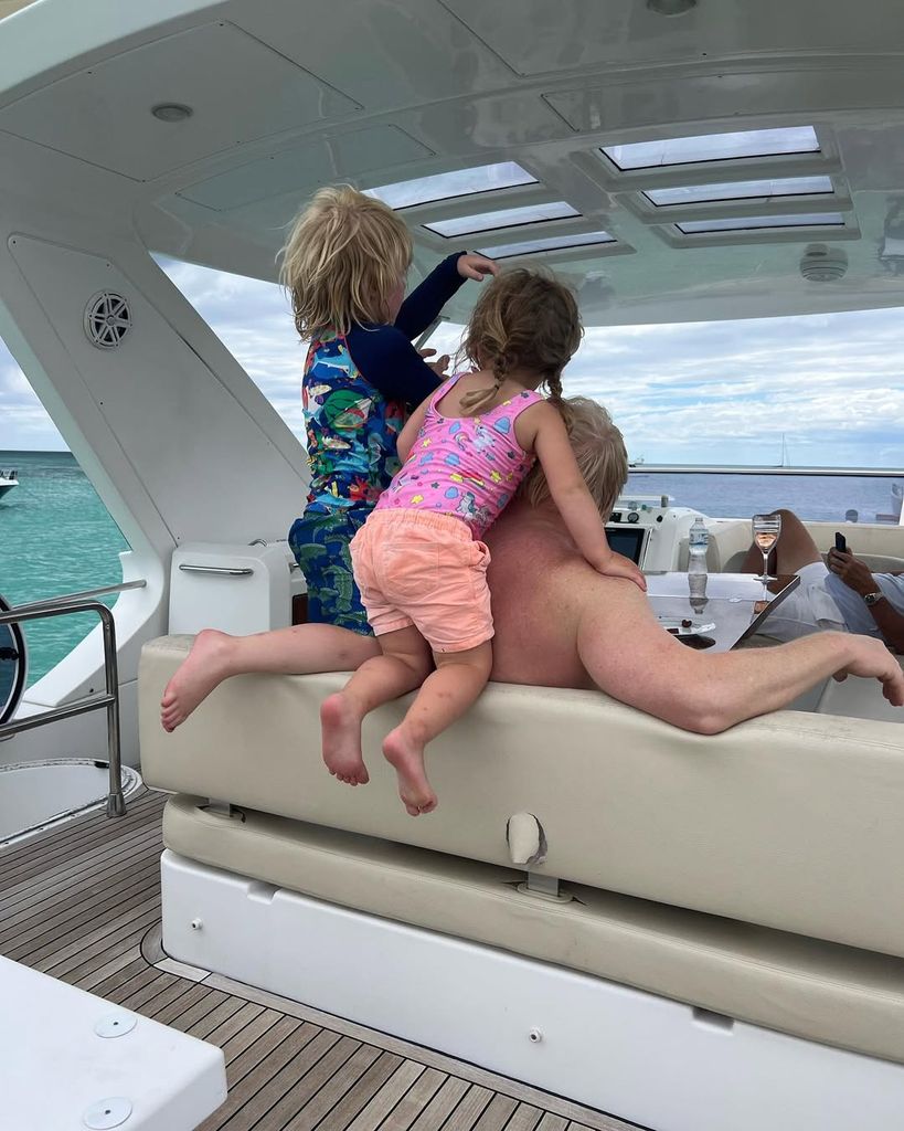 Romy Johnson and Wilfred Johnson playing with their dad Boris Johnson's hair on a boat