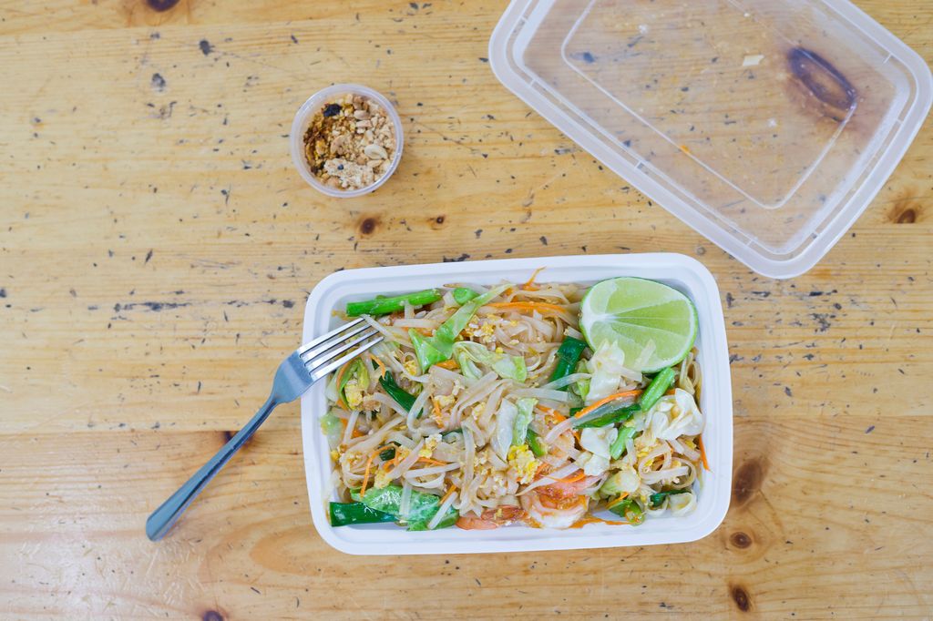 A plastic container with the contents of a noodle meal