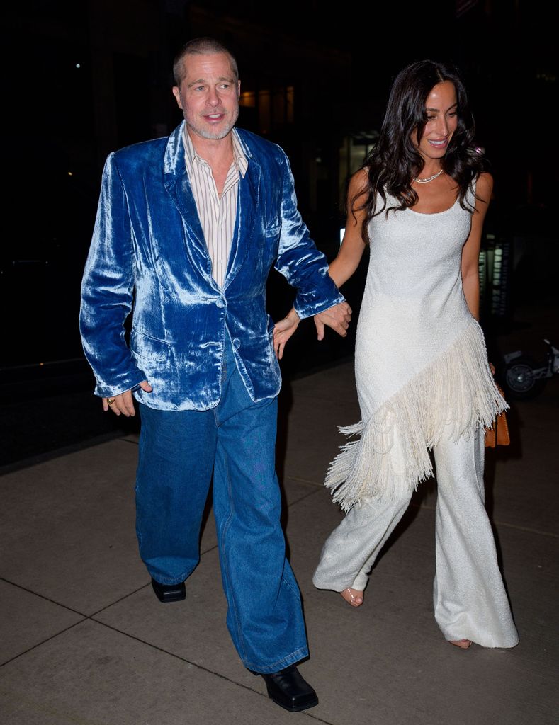 Brad Pitt wears a blue velvet blazer and blue trousers, hand in hand with girlfriend Ines de Ramon