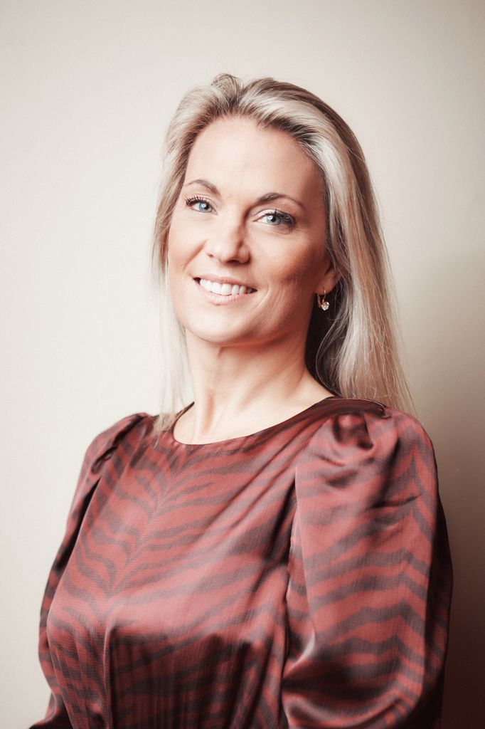 Blonde woman in a rust-coloured silky zebra print dress