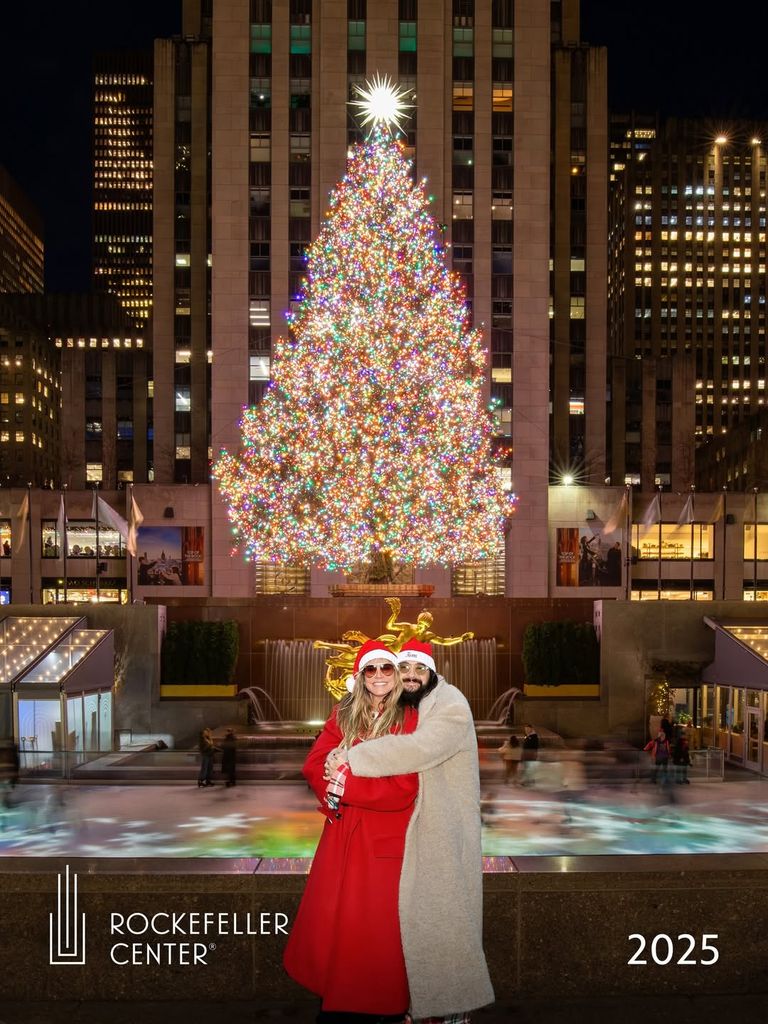 Heidi klum and Tom kaulitz posing in front of the Rockefeller Center Christmas Tree 
