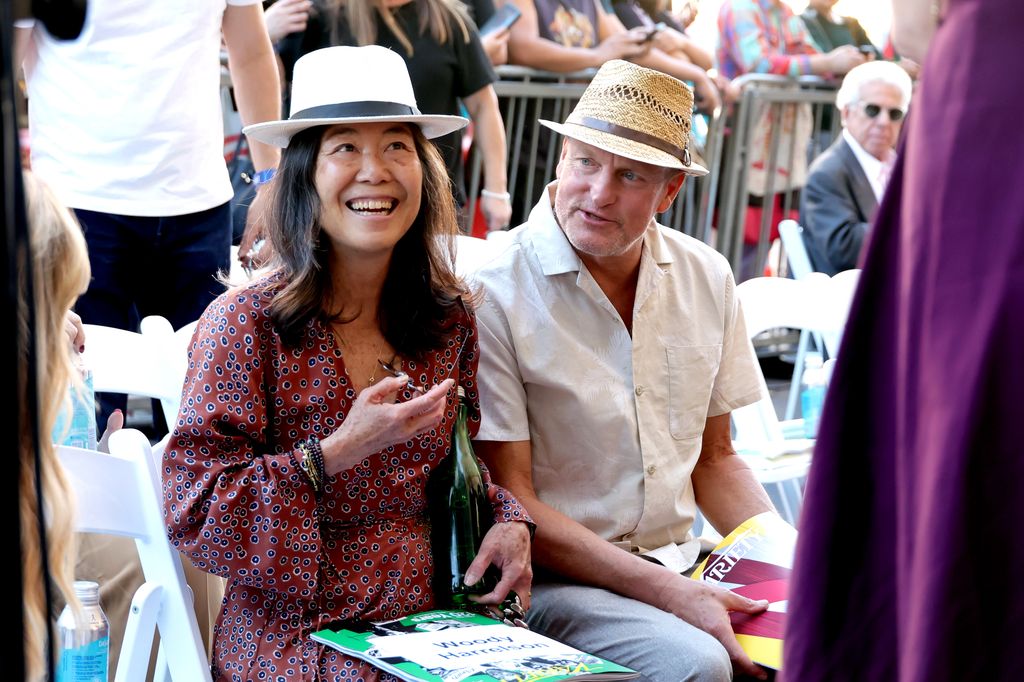 Laura Louie in printed dress and straw hat and Woody Harrelson in hat and white shirt attended the Star Ceremony honoring James L. Brooks on The Hollywood Walk of Fame