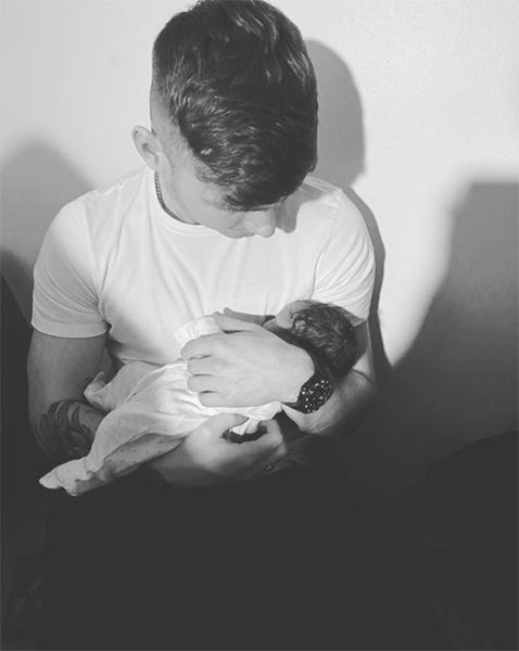 Jack Keating holding a baby