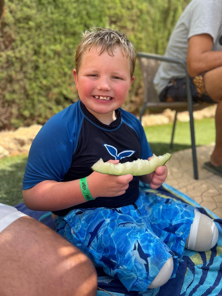 young boy eating melon 