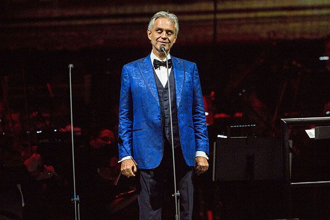 andrea bocelli in blue suit sings on stage