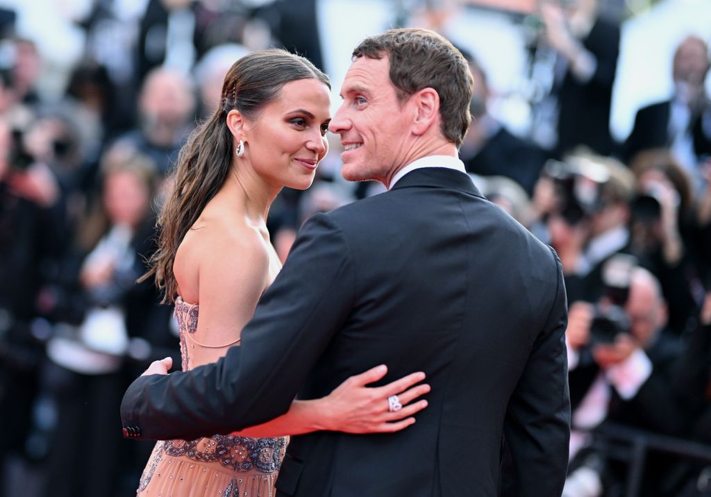 Alicia Vikander and Michael Fassbender hugging on the red carpet