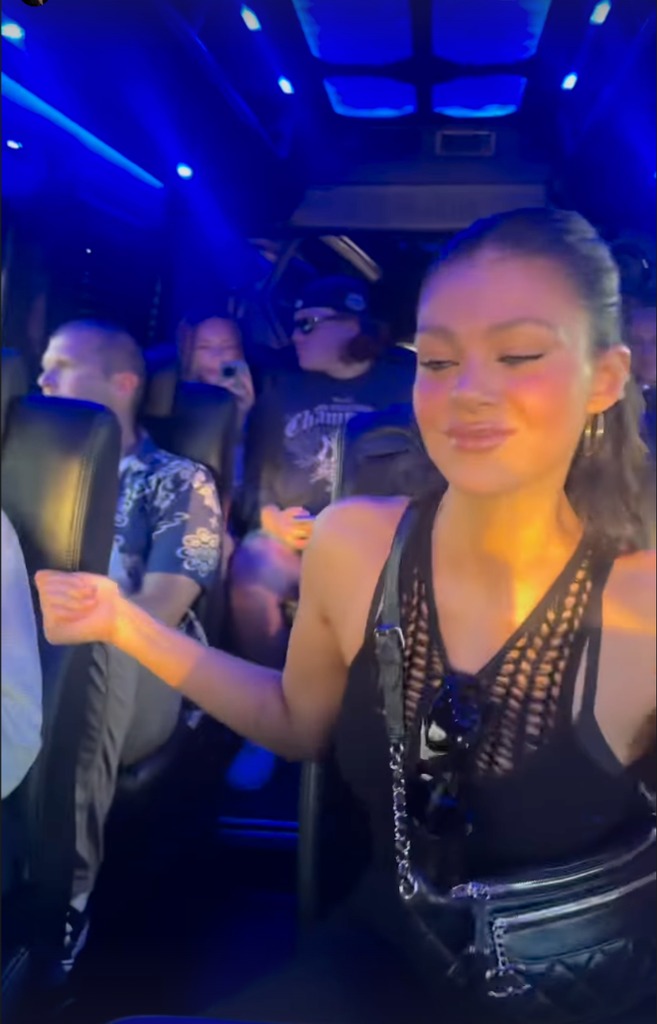 Nicola Beckham on a coach at Coachella, wearing a Chanel bumbag and a black crochet tank top