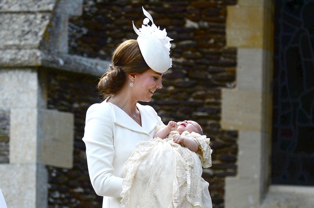 kate middleton in white holding baby charlotte
