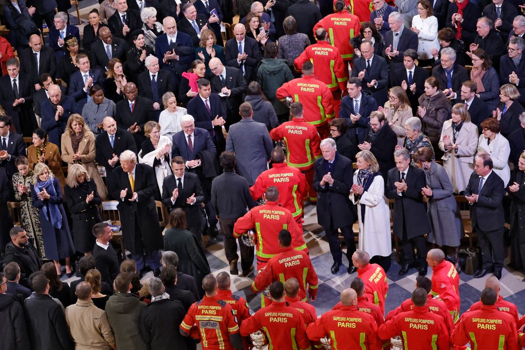 Firefighters, rescuers and builders involved in the restoration of Notre-Dame Cathedral parade during a ceremony to mark the re-opening of landmark cathedral