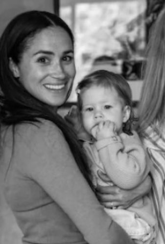 Meghan Markle smiles as she holds daughter Lilibet