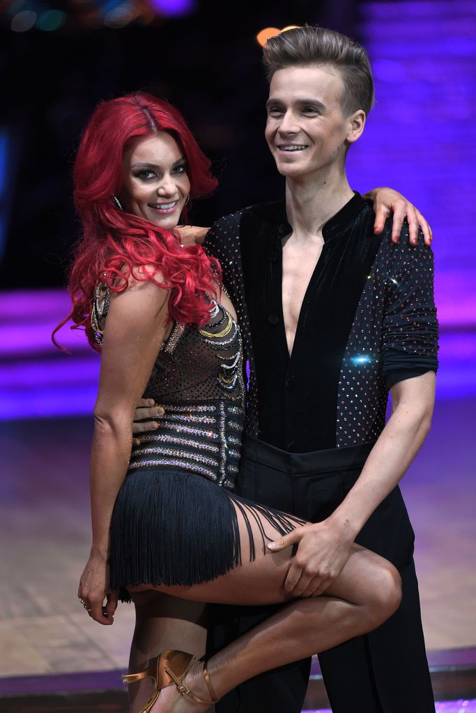 Dianne Buswell with her leg being held by Joe Sugg