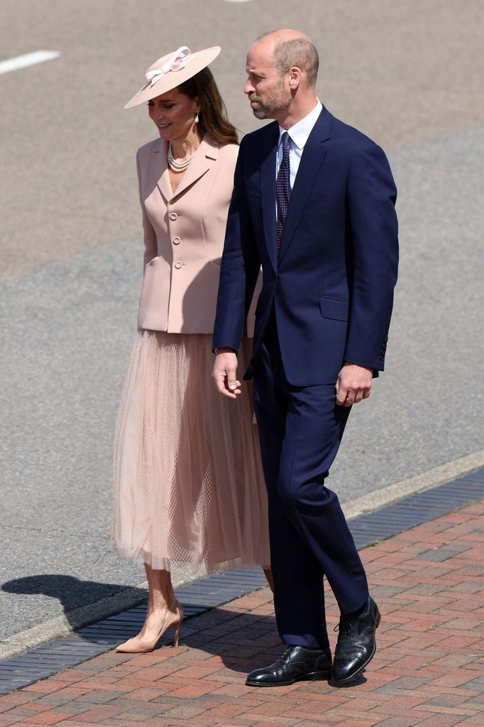 Kate in soft pink outfit beside william in suit