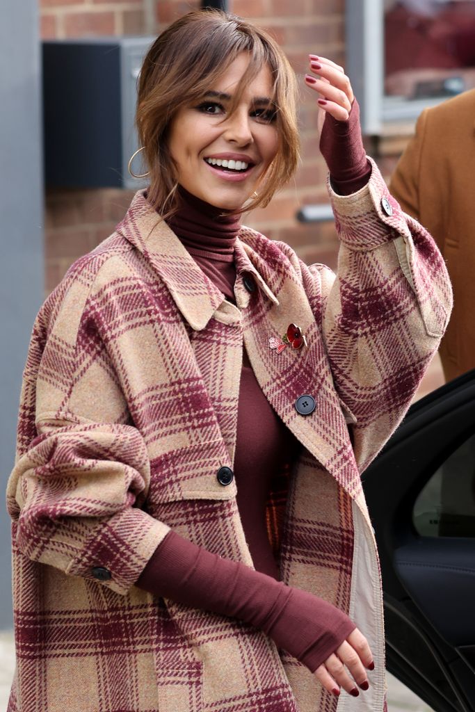 Cheryl in a tweed coat and maroon outfit