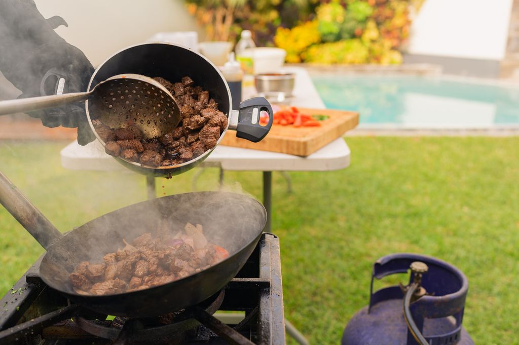 Personne cuisinée dans un jardin avec piscine