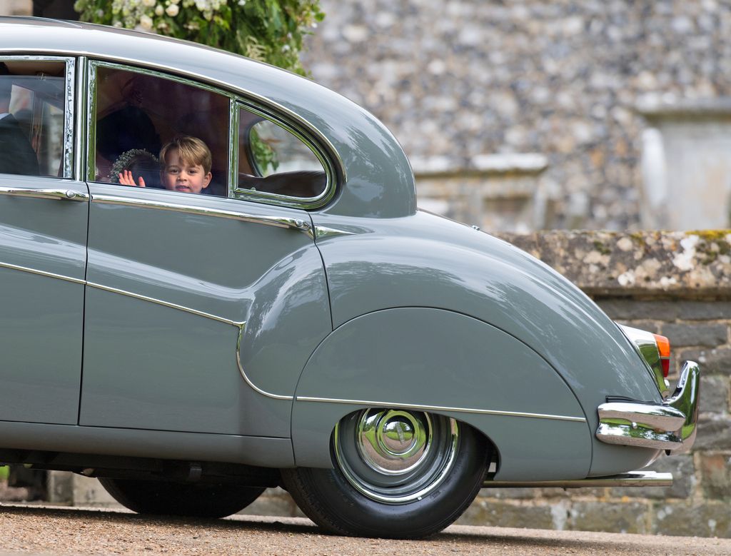 Prince George waving in the back of a car