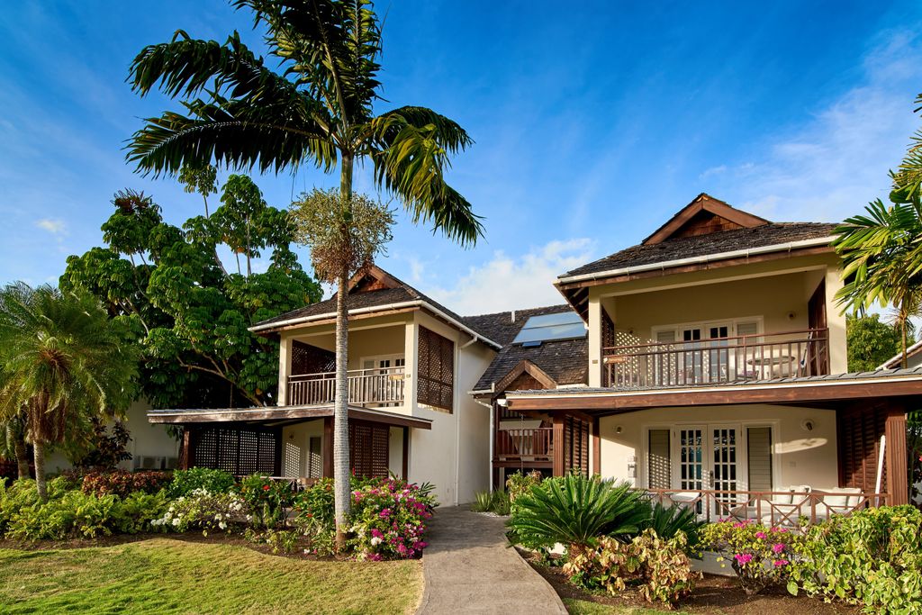 two story accommodation surrounded by palm trees and flowers
