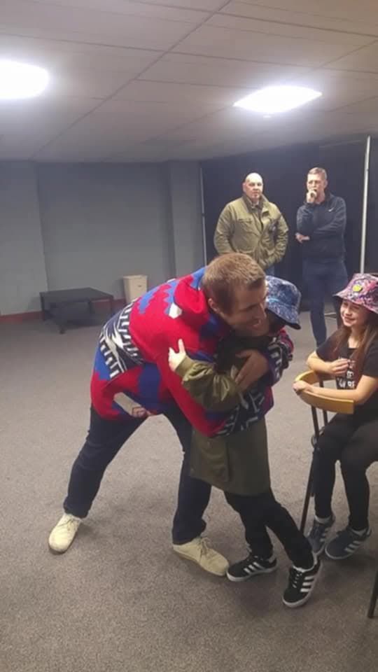 Luca Flynn being hugged by Liam Gallagher backstage