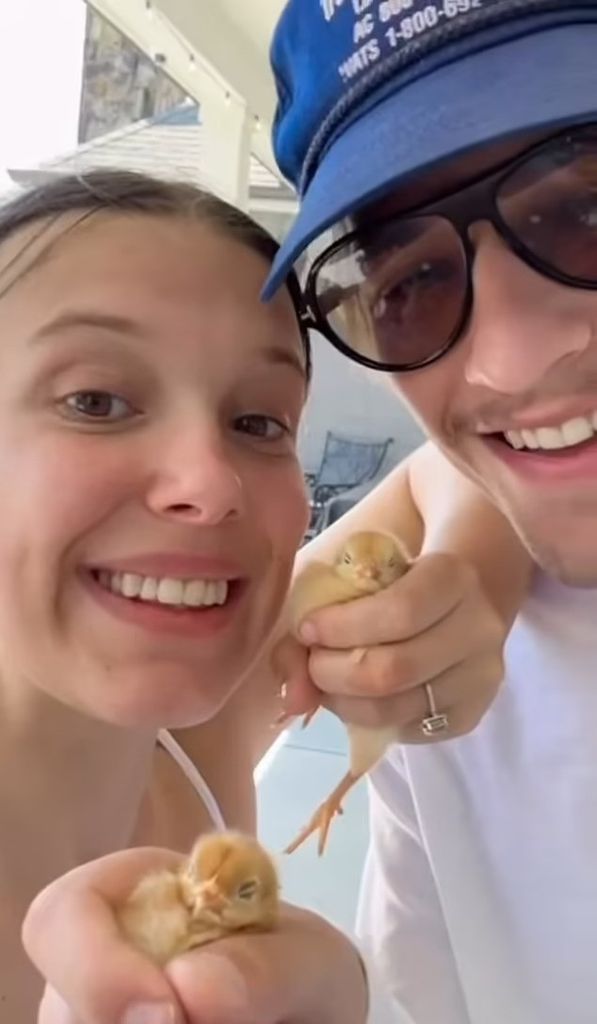 millie bobby brown and jake bongiovi holding a chick