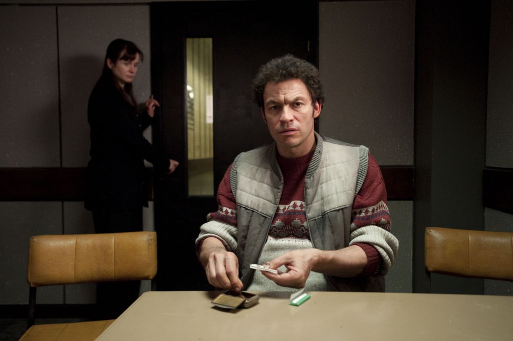 man rolling cigarette in interrogation room 