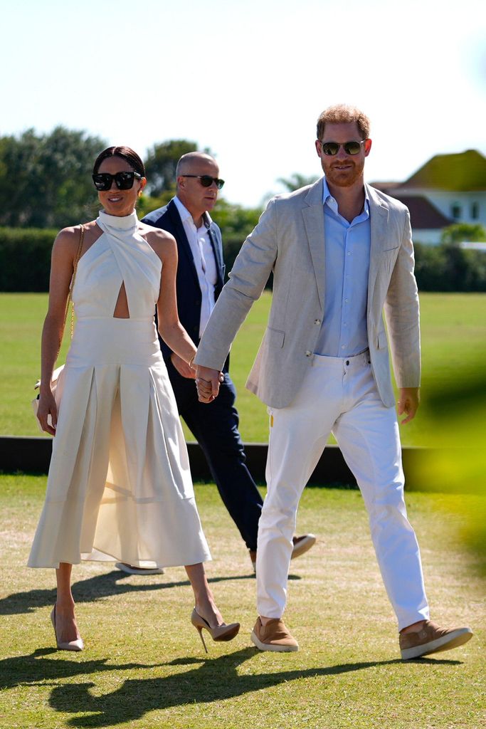 The couple held hands as the arrived at the polo