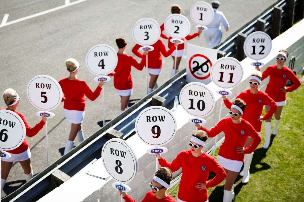 Women dressed in vintage England football kit parade on the race track during the Goodwood Revival at Goodwood on September 11, 2016 in Chichester, England.  