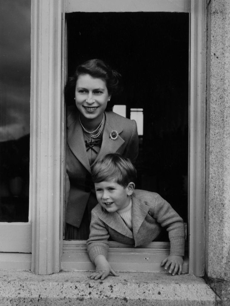 The late Queen and Charles leaning out of a window at Balmoral Castle, Scotland in 1952