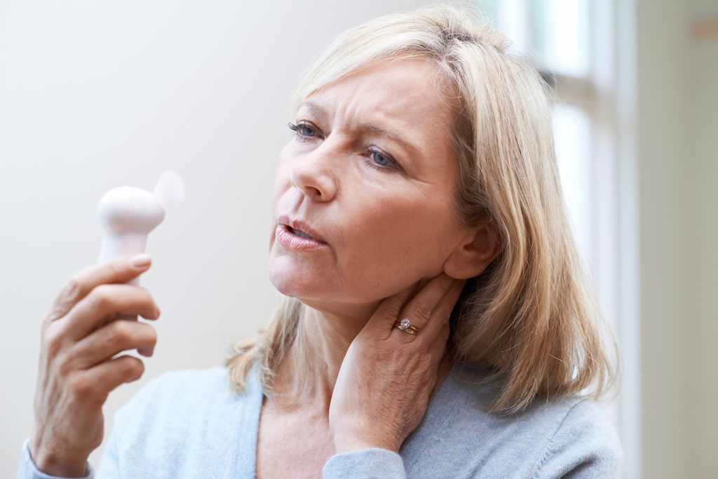 woman holding fan during hot flush