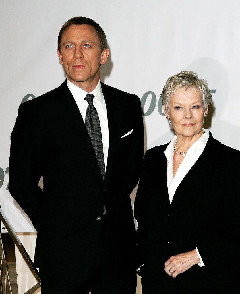 Dame Judi Dench in a black suit with Bond star Daniel Craig