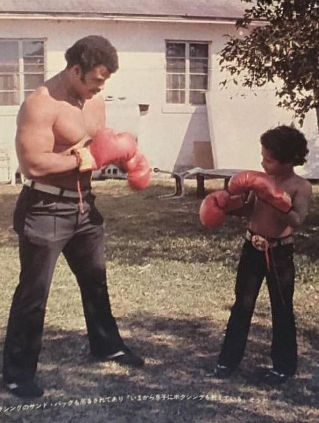 Dwayne boxing with his dad in the garden when he was a kid