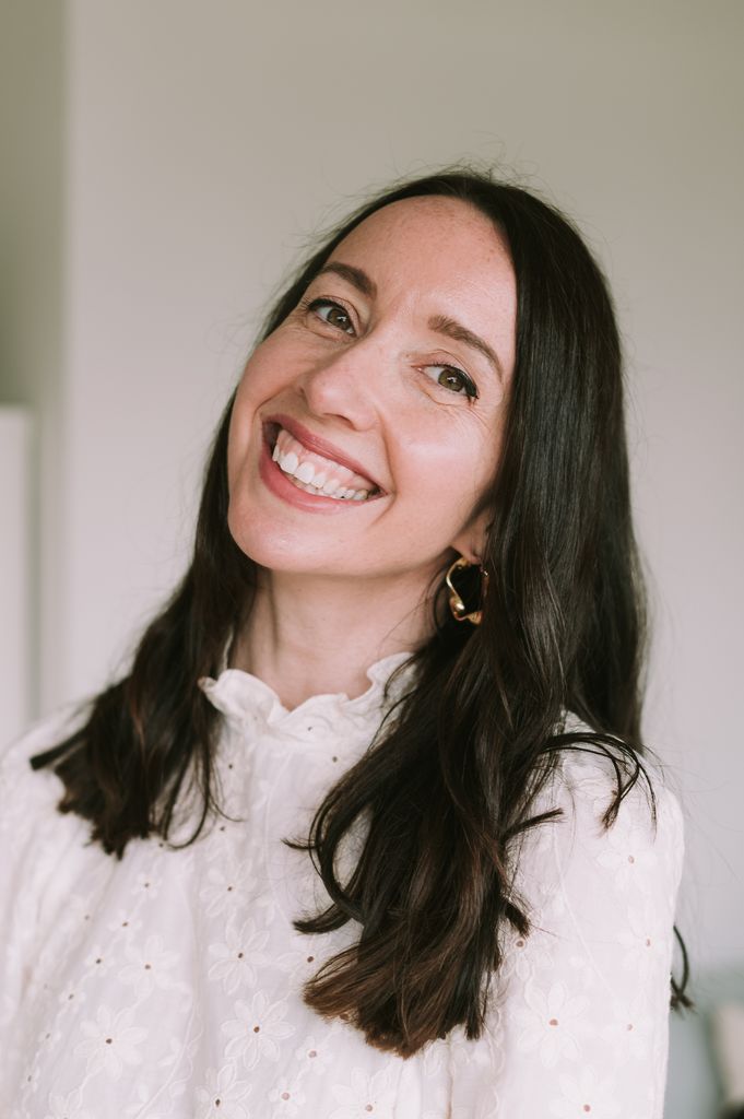 Brunette woman smiling in a white shirt 