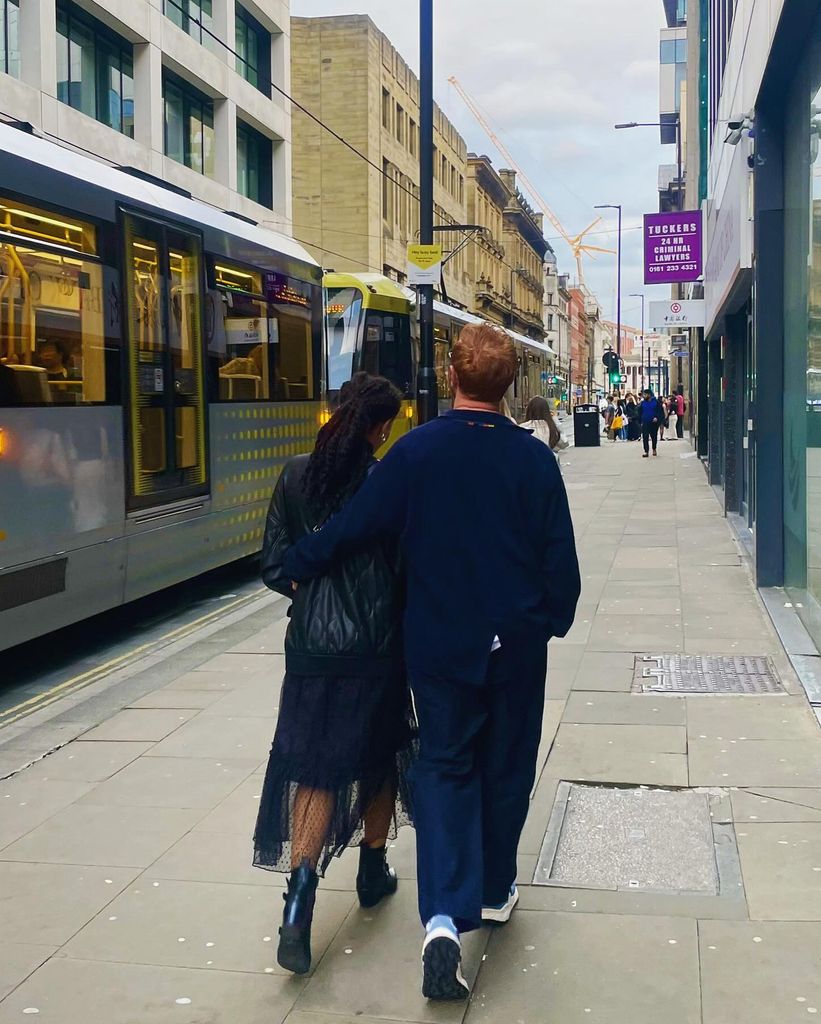 Michelle and husband from behind walking down street