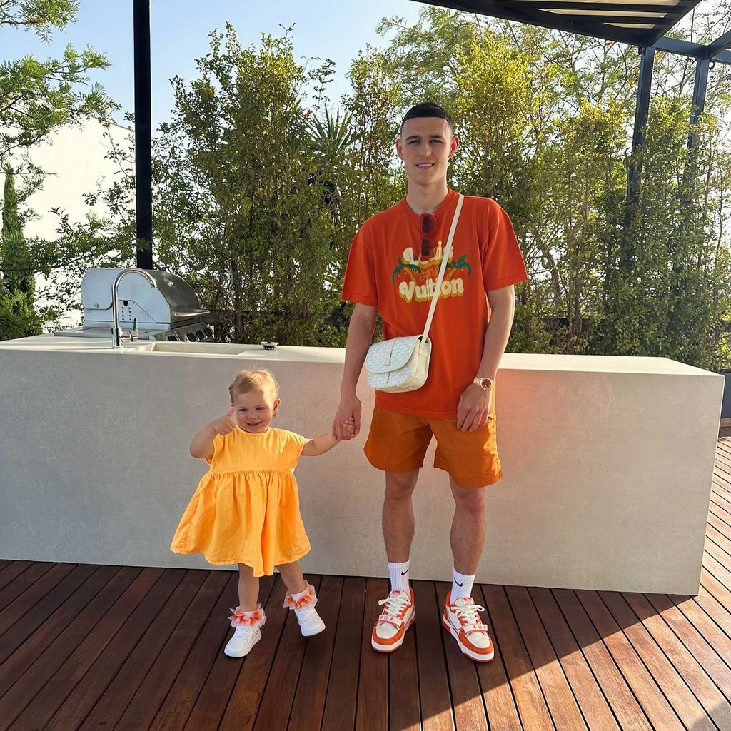 A photo of Phil Foden holding his daughter's hand 