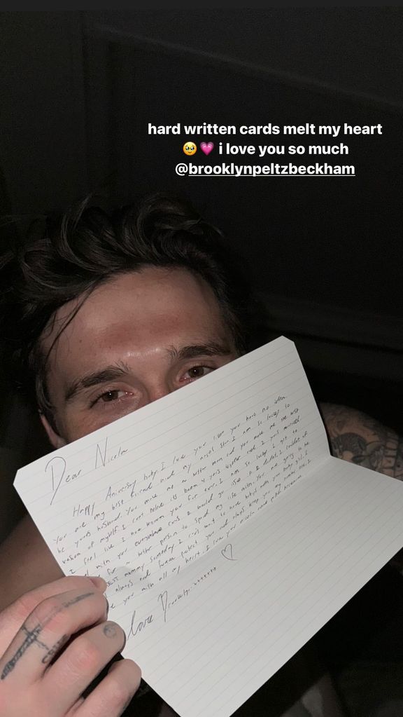 Brooklyn Beckham holding up a handwritten note