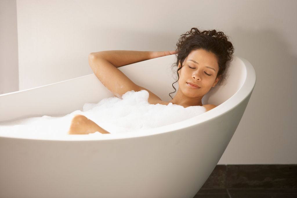 Woman sleeping in bubble bath