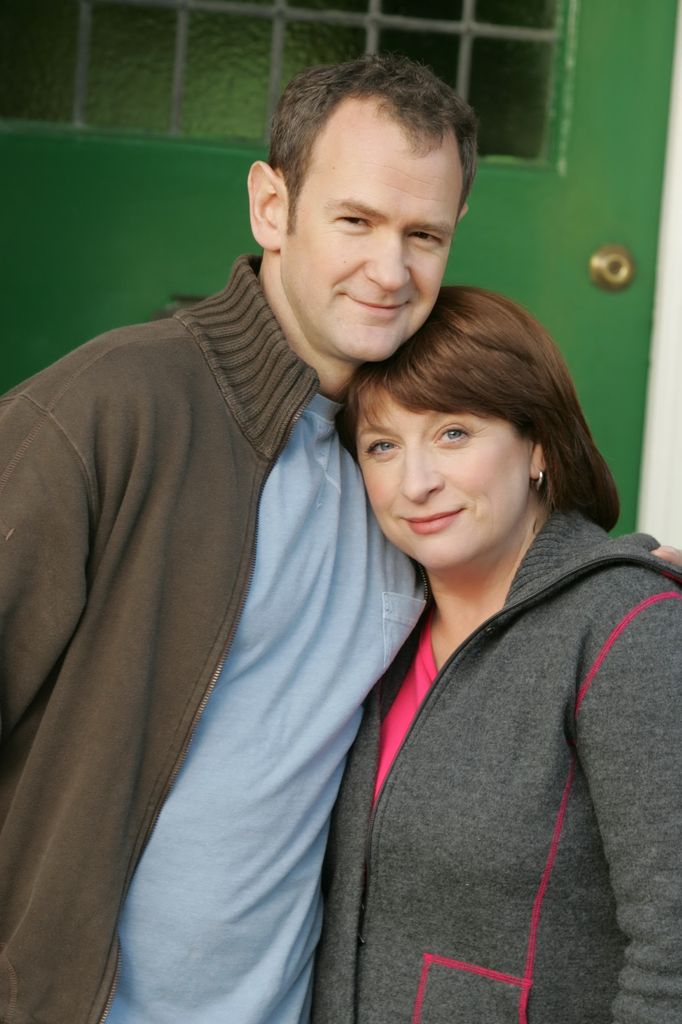 man and woman hugging outside green door