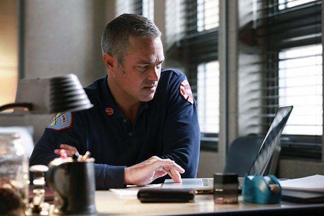 Taylor Kinney as Severide sits at desk