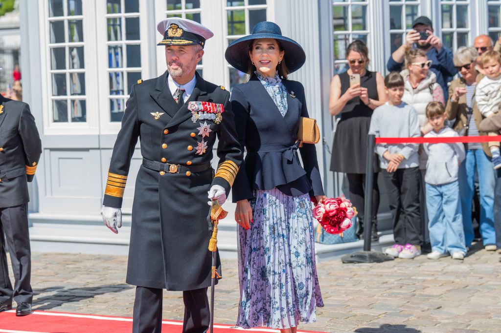 King Frederik in a naval uniform and Queen Mary in a blue outfit