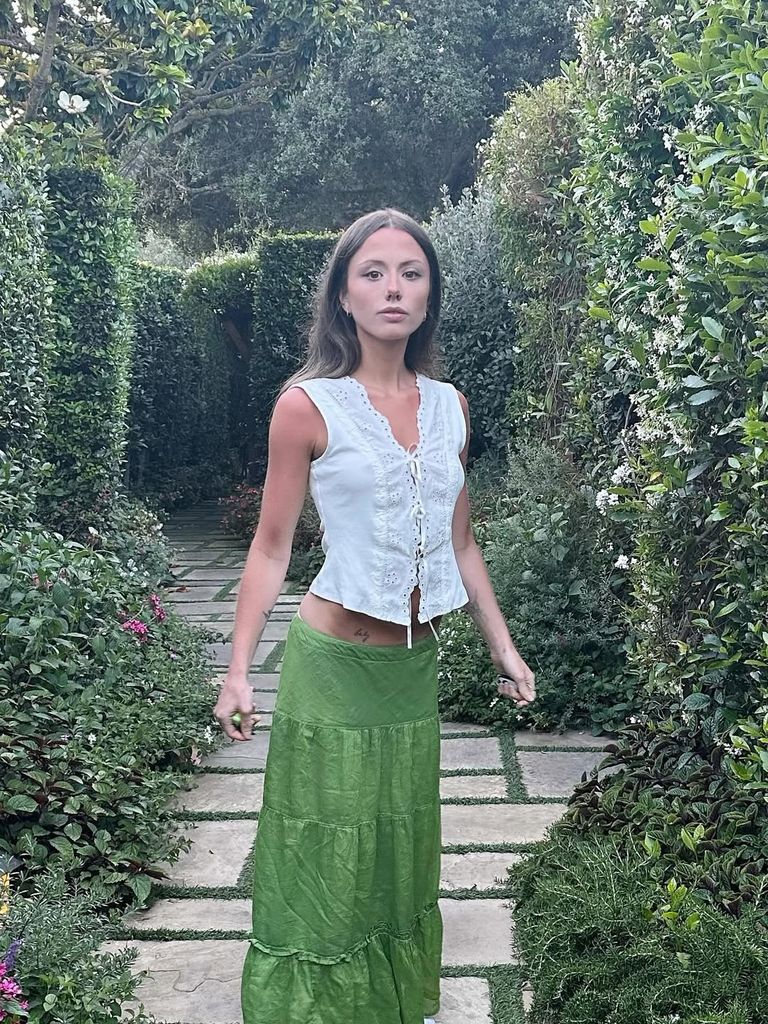Kate's daughter  Lily poses on vacation in a green skirt and pretty white top