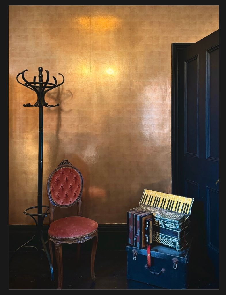 a space with a gold wall and chair