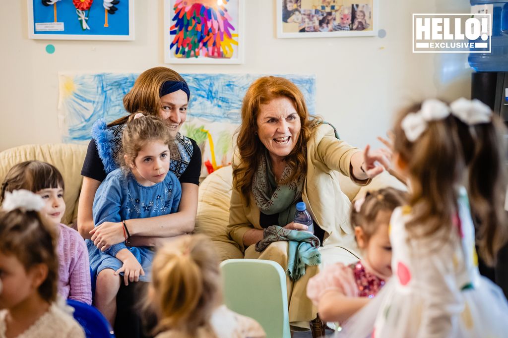 Duchess Sarah of York in cream blazer chatting to children at Tikva