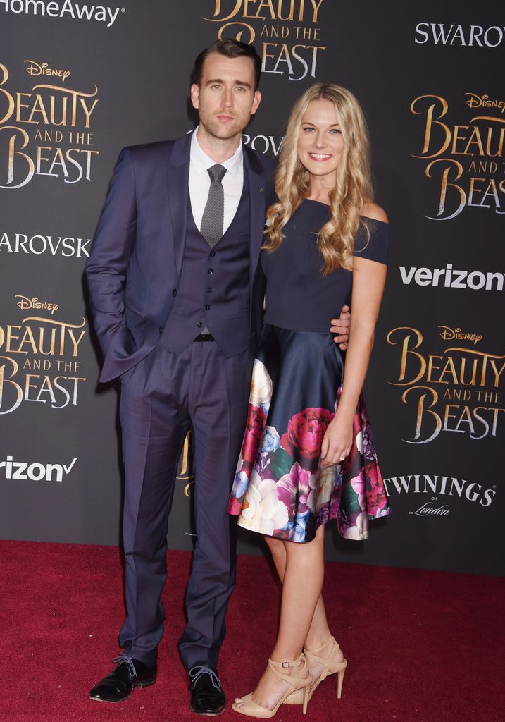 man and woman smiling for photo on red carpet