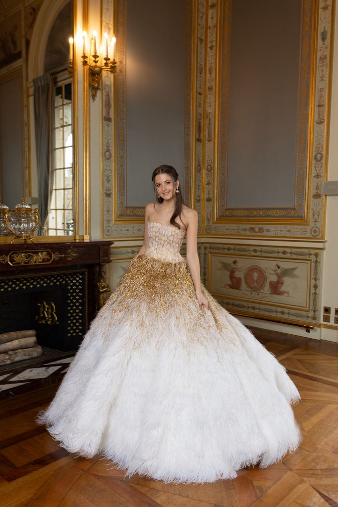 Josephine Haas posed in grand room in gold and white dress