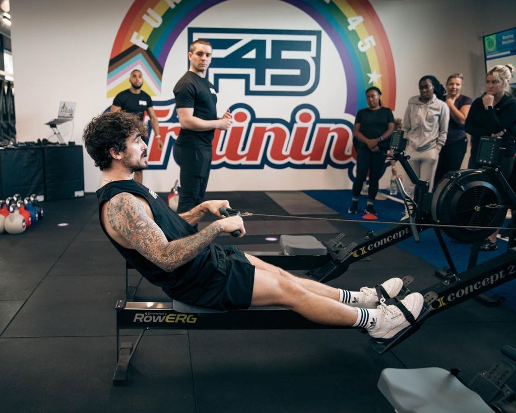 A f45 fitness coach demonstrates how to use the rowing machine 